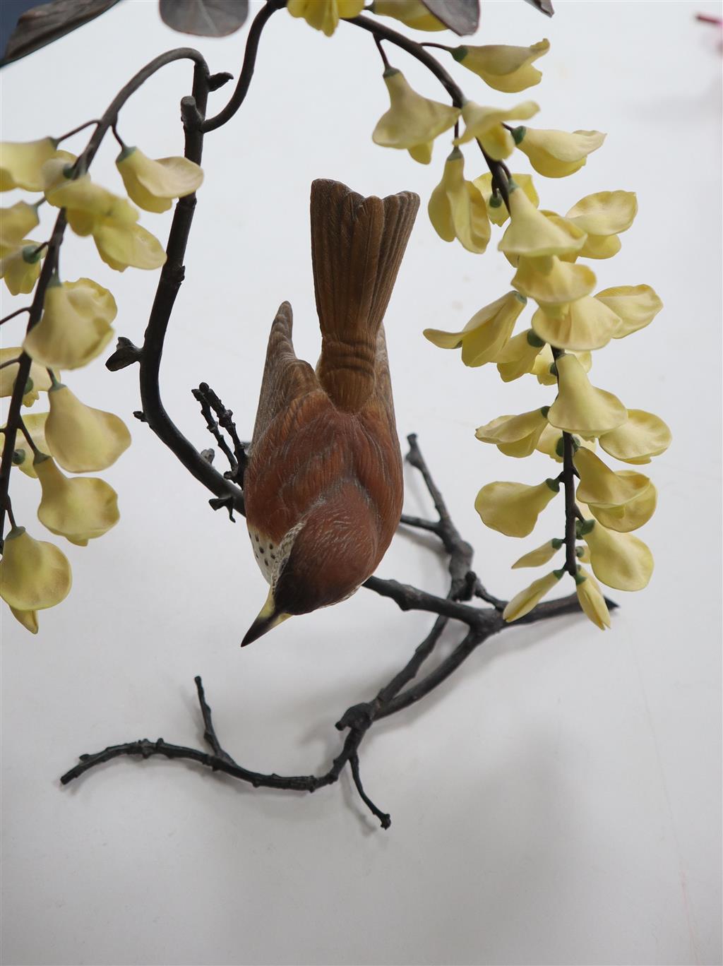 A Boehm model Thrush on a branch with yellow wisteria, and a Coal Tit Thrush on a branch surrounded by lilac wisteria, tallest 29cm